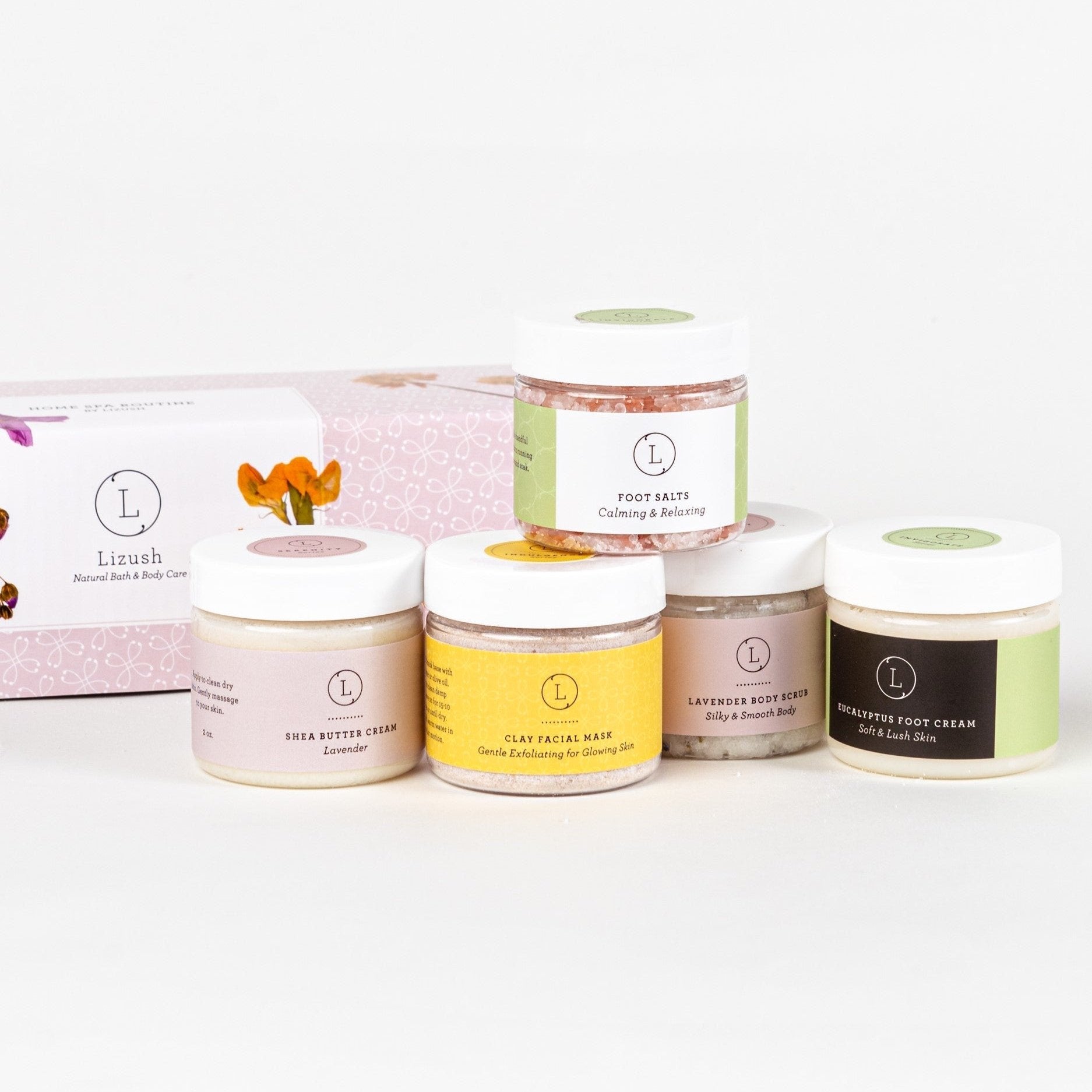 Home Spa Routine gift set displayed, featuring a collection of luxurious self-care products designed to create a spa-like experience at home. The set includes a 3 oz foot salt to soothe and revitalize, a 3 oz body scrub for exfoliation and nourishment, a 1.3 oz facial clay mask for detoxifying and refreshing the skin, a 2 oz shea butter cream for deep hydration, and a 2 oz foot cream for pampering relief. All items are beautifully packaged in an elegant gift box, making it an ideal present for birthdays, an