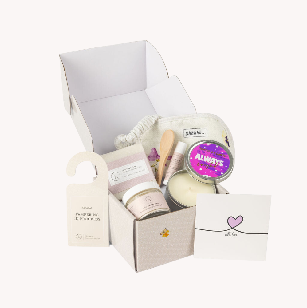 Lavender Bath and Body Gift Set, a beautifully curated thank you gift box designed for her. This all-natural spa set is perfect for expressing appreciation and includes a 1oz clay facial mask, a 4oz lavender natural soap bar, a scented soy candle, an unscented natural lip balm, and a cotton eye mask for ultimate relaxation. The set is packaged in a customizable gift box where a name can be added to the lid, making it extra special, and includes a personalized greeting card for a unique touch. Ideal for than